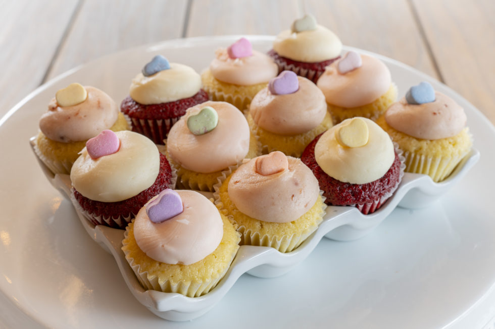 12 mini cupcakes in Spring colors on a white dish from Bird Bakery in San Antonio Texas